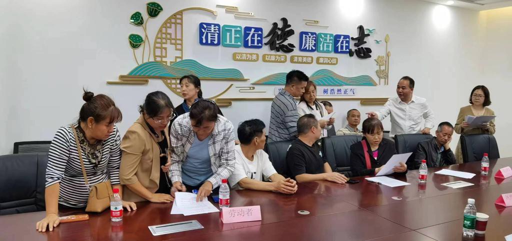 图为广州市白云区劳动人事争议仲裁院院长李拥华(后排右二)在调解欠薪争议现场。(广州市白云区劳动人事争议仲裁院供图)